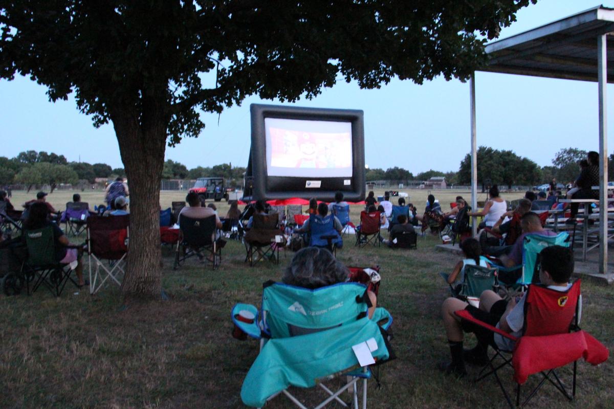 Movie screen and people at the park